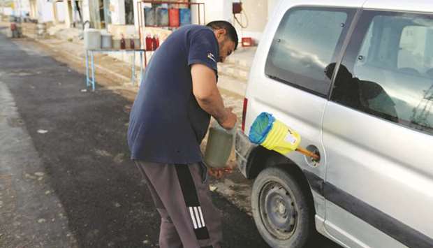 A man fills a vehicle with gasoline in Ben Guerdane, near the Libyan border in Tunisia on May 26. Tunisiau2019s economic reform blueprint relies on boosting taxes, paring energy subsidies and cutting other costs.
