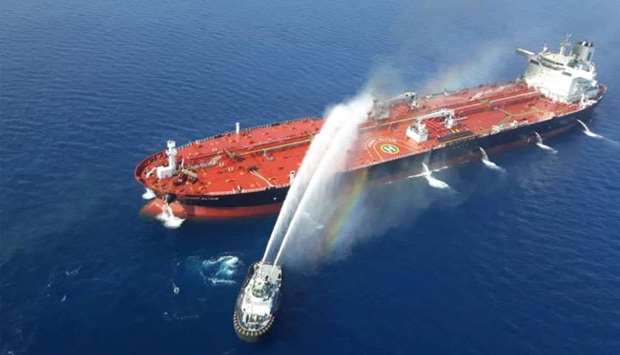 An Iranian navy boat tries to stop the fire of an oil tanker after it was attacked in the Gulf of Om