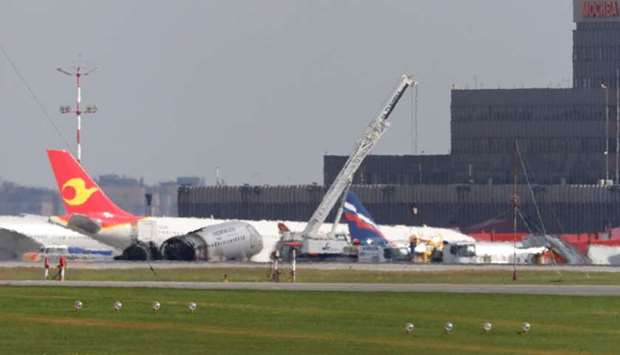 Members of emergency services operate a crane at the scene of an incident involving an Aeroflot Sukhoi Superjet 100 passenger plane at Moscow's Sheremetyevo airport, Russia May 6, 2019