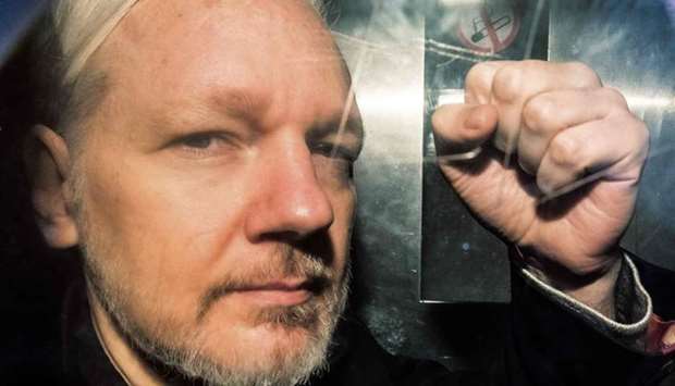 In this file photo taken on May 1, 2019 WikiLeaks founder Julian Assange gestures from the window of a prison van as he is driven into Southwark Crown Court in London, before being sentenced to 50 weeks in prison for breaching his bail conditions in 2012.