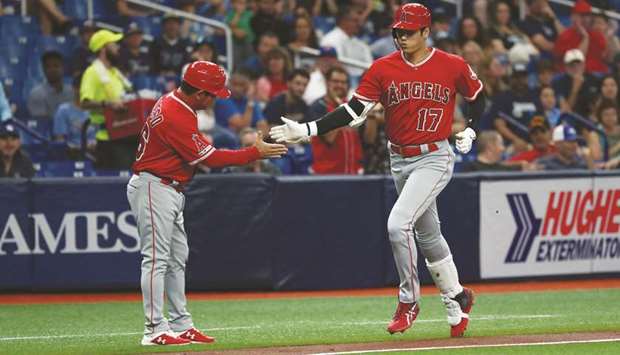 Los Angeles Angels designated hitter Shohei Ohtani (right) is congratulated by third base coach Mike Gallego on his three-run home run during the first inning against the Tampa Bay Rays in St. Petersburg, Florida, on Friday night. (USA TODAY Sports)