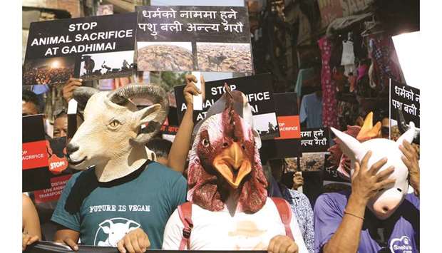Animal rights activists hold placards and wear animal masks as they protest against the mass slaughter of animals that takes place every five years during Nepalu2019s festival of Gadhimai, which is set to take place later this year, in Kathmandu yesterday.