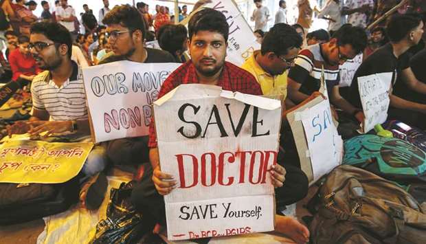 A doctor holds a placard at a government hospital during a strike demanding security after the recent assaults on doctors by the patientsu2019 relatives, in Kolkata, yesterday.