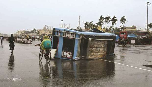 People move past a damaged vehicle after Cyclone Fani hit Puri, in the eastern state of Odisha, India, in this May 3 file photo.