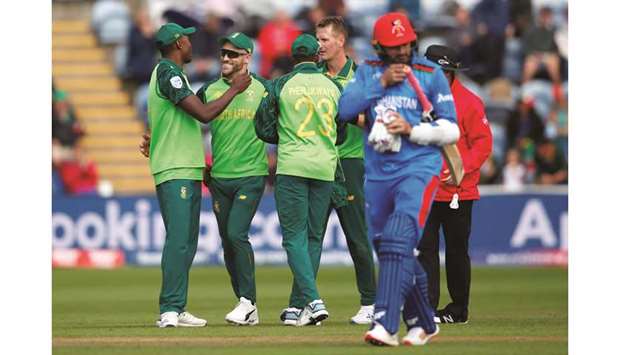 South Africau2019s Chris Morris (second from right) celebrates with Faf du Plessis (second from left) and teammates after taking the wicket of Afghanistanu2019s Hamid Hassan (foreground) during the match in Cardiff, Wales, on Saturday. (Reuters)