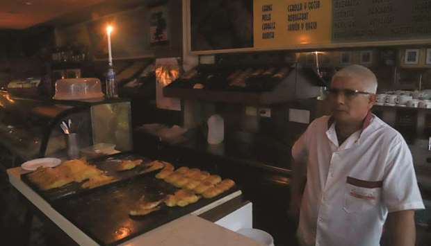 A man works by a candle light at a bakery during a power cut in Buenos Aires yesterday.
