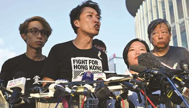 Civil Human Rights Front (CHRF) member Jimmy Sham, centre, speaks during a press conference in Hong Kong yesterday after Hong Kong Chief Executive Carrie Lam suspended a hugely divisive bill that would allow extraditions to China in a major climbdown after a week of unprecedented protests and political unrest.