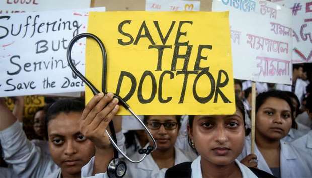 A doctor holds a placard at a government hospital during a strike demanding security after the recent assaults on doctors by the patients' relatives, in Agartala
