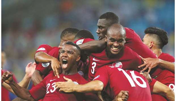 Qatar players celebrate Boualem Khoukhiu2019s goal in the second half of their match against Paraguay on Sunday.