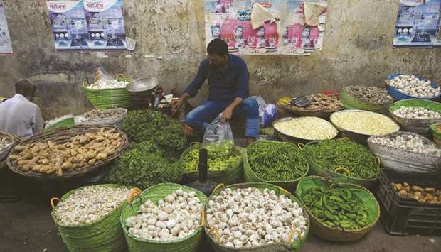 A shopkeeper arranges vegetables in his shop at a market in Karachi. The higher cost of edibles will hike the kitchen budget or the quality of the food intake will be compromised.