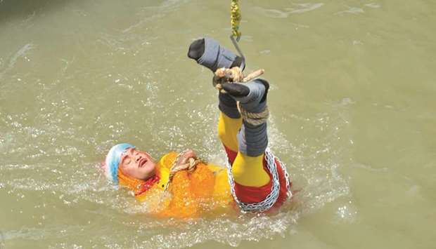 Chanchal Lahiri is lowered into the Hooghly river as he performs one of his tricks in Kolkata, on June 16. His body was later recovered by police.