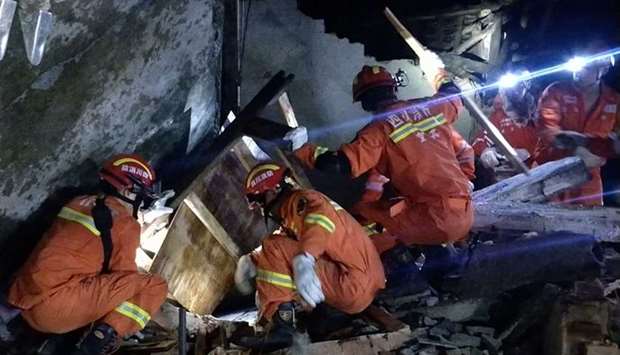 Rescuers search for earthquake survivors in the rubble of a building in Yibin, in China's southwest Sichuan province, early today.