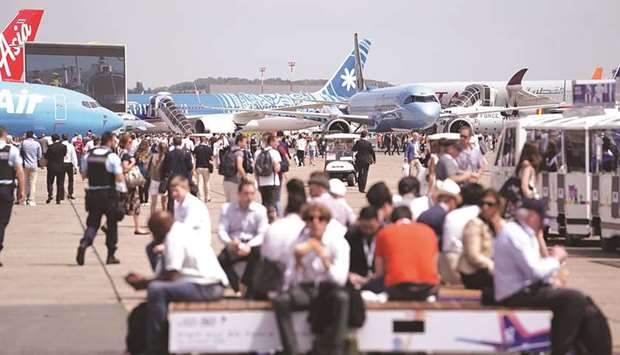 Attendees walk between passenger aircraft on display during the 53rd International Paris Airshow at Le Bourget in Paris yesterday.
