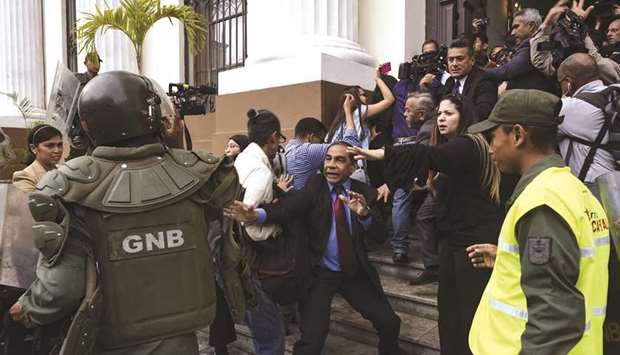 Deputies of the National Assembly struggle with members of the Bolivarian National Guard to allow journalists and technicians access the plenary meeting of the National Assembly in Caracas, Venezuela, yesterday.