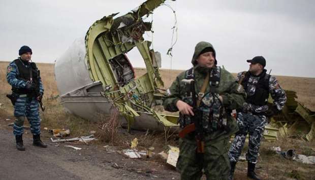 In this file photo taken on November 11, 2014 pro-Russian gunmen stand guard as Dutch investigators (unseen) arrive near parts of the Malaysia Airlines Flight MH17 at the crash site near the Grabove village in eastern Ukraine on November 11, 2014