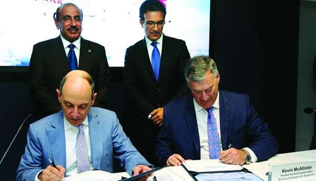 HE al-Baker and Kevin G McAllister, president and CEO of Boeing Commercial Airplanes, sign the agreement in the presence of HE al-Sulaiti at the Paris Air Show