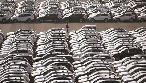 A worker is seen among newly manufactured cars awaiting export at a port in Yokohama. Japanu2019s exports declined 7.8% in May from a year earlier, down for the sixth straight month, Ministry of Finance data showed yesterday.