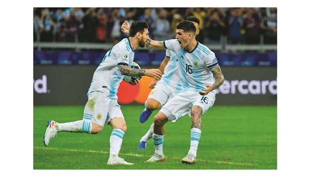 Argentinau2019s Lionel Messi (L) celebrates with teammate Rodrigo De Paul after scoring a penalty against Paraguay in Belo Horizonte yesterday.