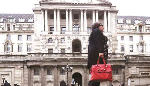 A pedestrian walks near the Bank of England in London. BoE policymakers, as expected, voted unanimously to keep interest rates on hold at 0.75% yesterday.