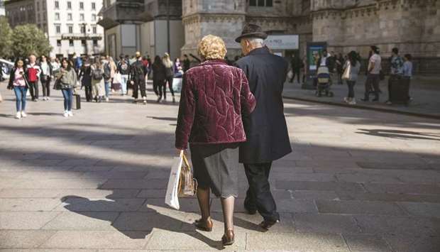 Elderly people carry shopping bags near Duomo cathedral in Milan. As Prime Minister Giuseppe Conte travels to Brussels for an EU summit, carrying a pledge for u201cconstructive dialogueu201d with the EU commission over the countryu2019s troubled finances, Italyu2019s statistics office Istat made the surprising announcement that the economy is likely to shrink again this quarter.