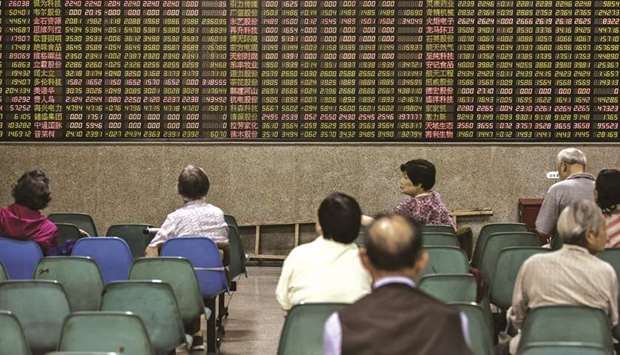 Investors sit in front of an electronic stock board at a securities brokerage in Shanghai. The Shanghai Composite Index rose 2.4% to 2,987.12 points yesterday.