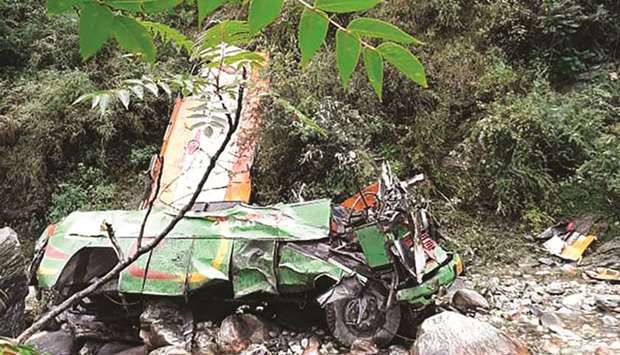 The wreckage of a bus carrying more than 60 passengers is seen after it fell into a gorge near Banjar, in the mountainous Kullu district of Himachal Pradesh yesterday.
