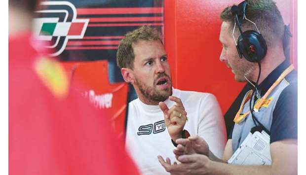 Ferrariu2019s German driver Sebastian Vettel (left) speaks with a technician in the pits during the practice session at the Circuit Paul Ricard in Le Castellet, southern France, ahead of the Grand Prix de France. (AFP)