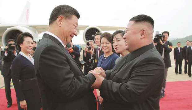 North Korean leader Kim Jong-un shaking hands with Chinese President Xi Jinping upon his arrival at Pyongyang international airport in Pyongyang.