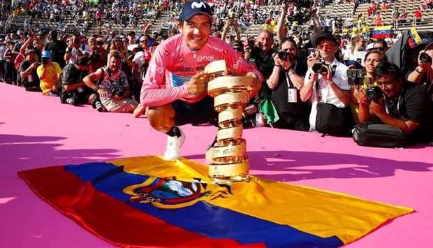 Ecuador's Richard Carapaz poses with the ,Never ending trophy, (Trofeo Senza Fine) by Ecuador's flag during podium ceremonies in the Verona arena, after the final stage of the 102nd Giro d'Italia