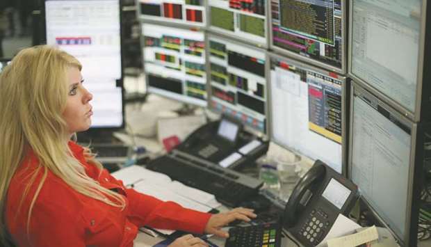 A trader monitors stock prices at the London Stock Exchange. The FTSE 100 was flat at 7,425.08 points yesterday.