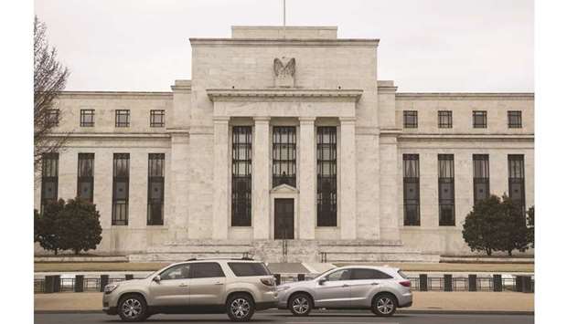 Vehicles pass in front of the Federal Reserve building in Washington, DC. The US Treasury market has diverged from the Fed in painting a bleak picture of future US economic growth and inflation, but the central bank looks unlikely to bend to the marketu2019s will anytime soon barring a notable turn for the worse.