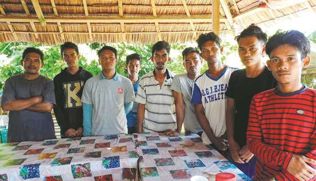 Nomadic fishermen pose for photographs after being freed by the Abu Sayyaf group at a military camp in Jolo, Sulu province on the southern island of Mindanao, yesterday.