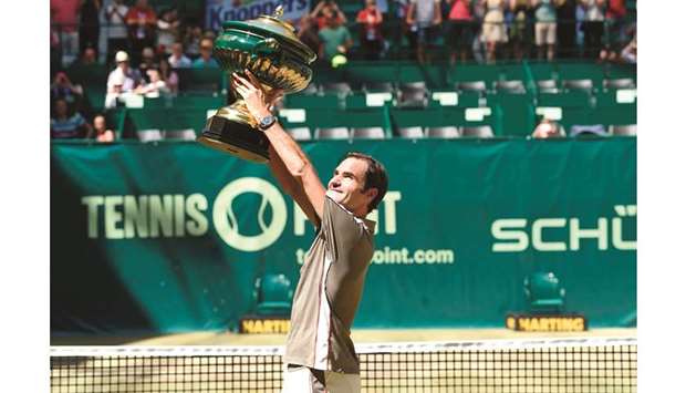 Roger Federer of Switzerland poses with the trophy after beating David Goffin of Belgium in Halle yesterday.
