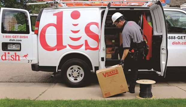 A Dish Network technician prepares to install a satellite television system at a home in Denver.