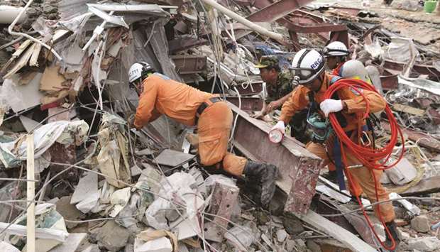 Rescue workers search for victims in the debris a day after an under-construction building collapsed in Sihanoukville yesterday.