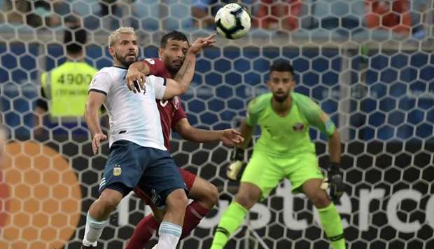Argentina's Sergio Aguero (L) and Qatar's Boualem Khoukhi vie for the ball during the Copa America football tournament group match at the Gremio Arena in Porto Alegre, Brazil