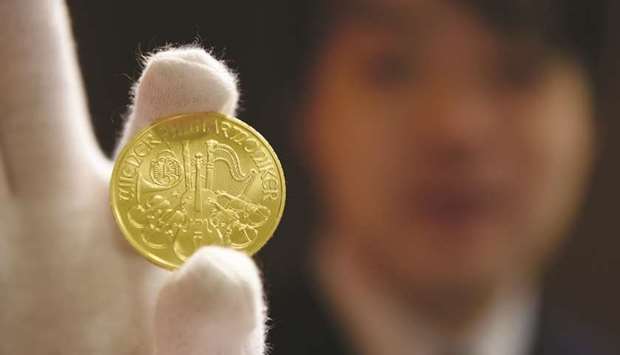 An employee holds a one-ounce gold coin for a photograph at a Tanaka Holdings store in Tokyo (file).
