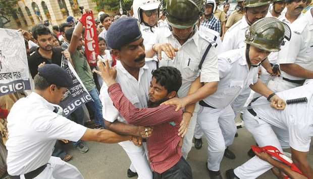 Police detain a demonstrator during a protest in Kolkata against the death of children this month in Bihar, from encephalitis, commonly known as brain fever.