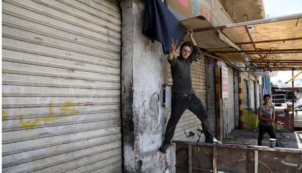A shop owner puts a black flag in front of his closed shop during a strike called by local activists against U.S. President Donald Trump's ,Deal of the Century, and Bahrain Conference, at Al-Baqaa Palestinian refugee camp, near Amman, Jordan