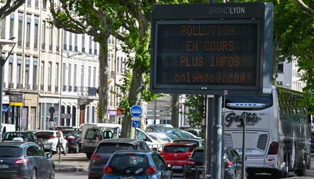 A digital diplay reads 'Ongoing pollution - more info on onlymoov' as cars drive in the French eastern city of Lyon as temperatures soar in Europe