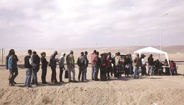 Venezuelan citizens line up at the Chacalluta border crossing between Chile and Peru, in Arica, Chile.