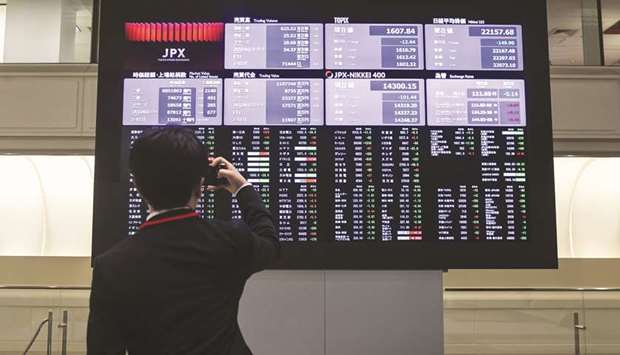 A man takes a photograph of a screen displaying share prices inside the Tokyo Stock Exchange (file).