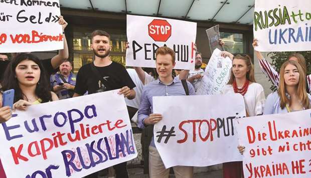 Activists holds placards as they shout slogans in front of the German embassy in Kyiv yesterday.