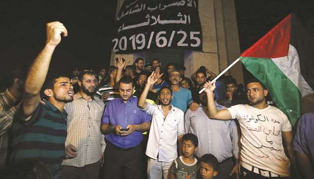 Palestinians chant slogans during a protest against the US-led Peace to Prosperity conference in Bahrain, in the southern Gaza Strip town of Rafah, yesterday.