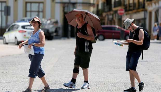 A tourist uses an umbrella to protect himself from the sun, as a heatwave hits Spain, in Ronda, southern Spain