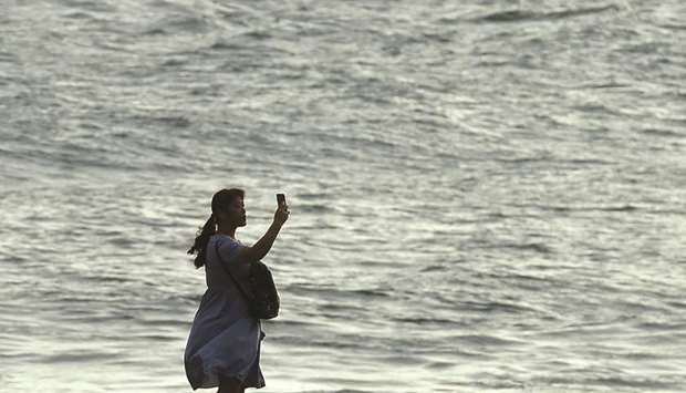 A tourist takes a selfie on the beach near the promenade of Galle Face, in Colombo.