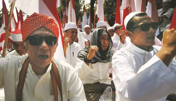 Men shout slogans as they take part in a protest near the area of Indonesiau2019s Constitutional Court.
