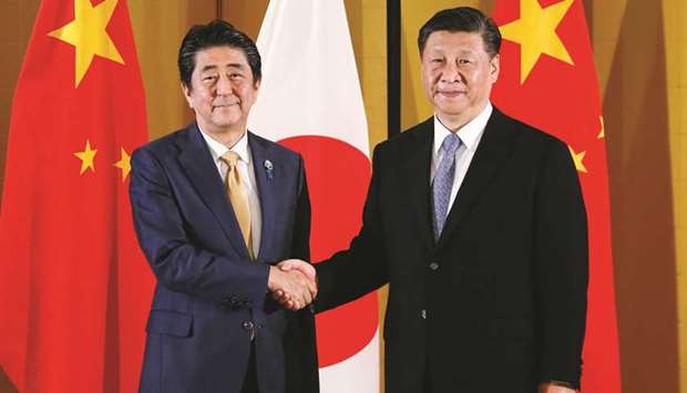 Japanese Prime Minister Shinzo Abe (left) shakes hands with Chinese President Xi Jinping at the start of their talks in Osaka yesterday.