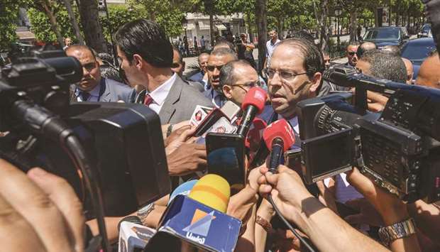 Tunisian Prime Minister Youssef Chahed speaks with journalists outside the Interior Ministry in Tunis yesterday.