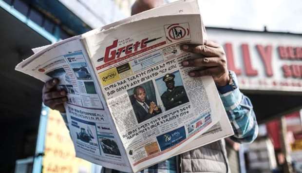 A man reads the Ethiopian newspaper 'The Reporter', depicting the portraits of killed Ambachew Mekonen (L), President of the Ahmara Region, and of Gen. Sere Mekonen, Chief of Staff of the Ethiopian National Forces, in Addis Ababa, on June 24